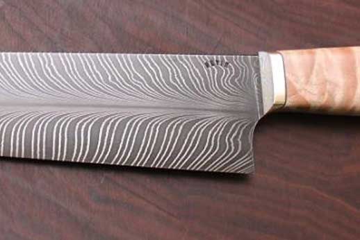 Double high carbon feather damascus, quilted maple handle, paper micarta buttcap, mokume guard and corby bolt.